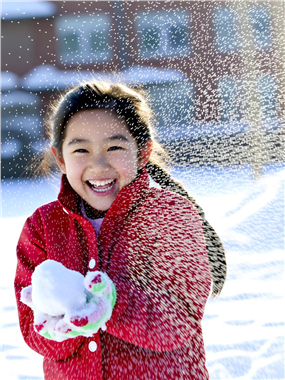 冬季雪地搓雪球的小女孩图片